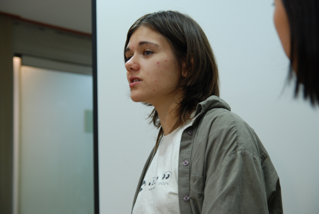 woman wearing a grey jacket looking in mirror