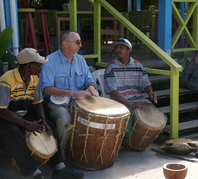 several guys sit with wooden drums on their lap