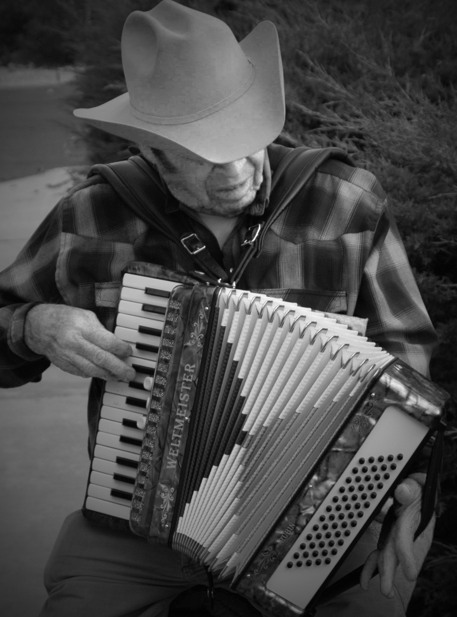 a man that is holding an accordion by the water