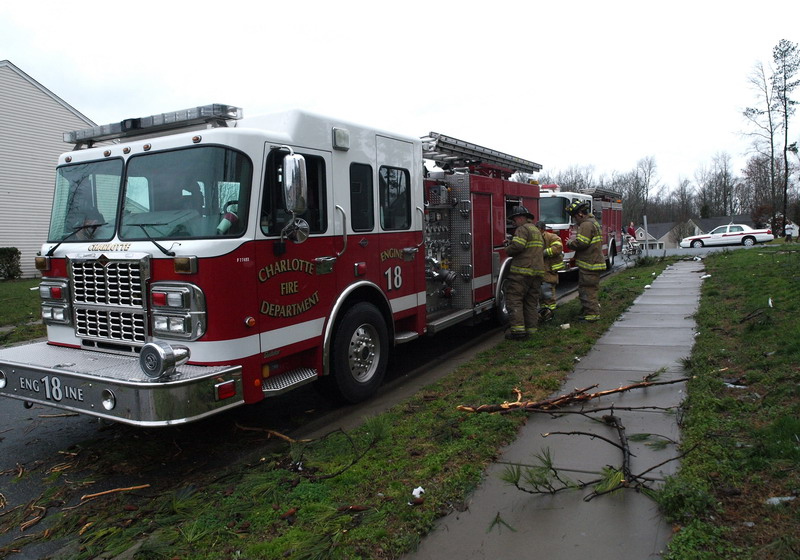 a fire truck with its ladder closed near some houses