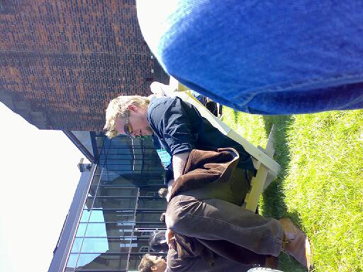 three people wearing brown pants laying down on the grass