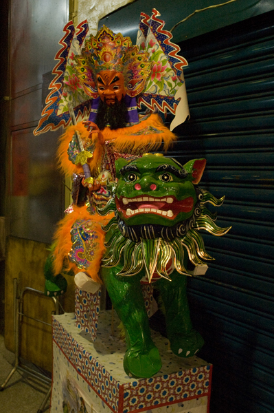 a green lion figure standing on top of a block