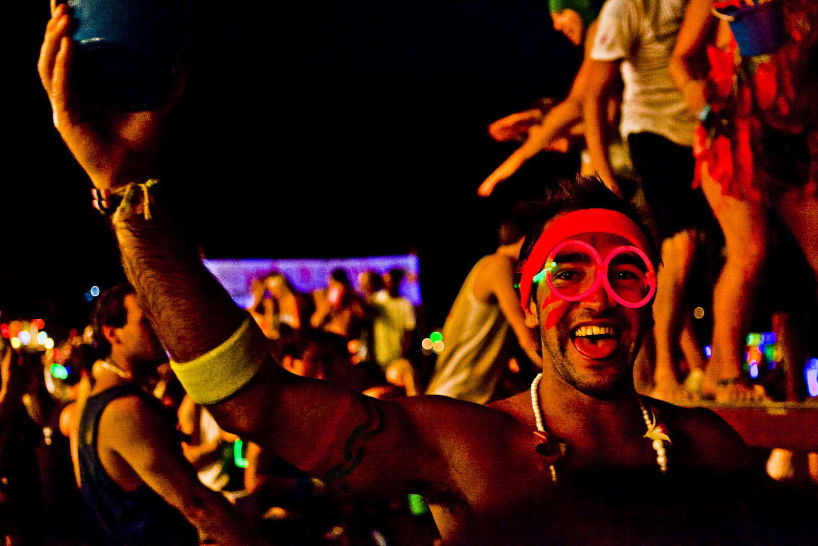 a man with pink eye patch smiling at a music festival