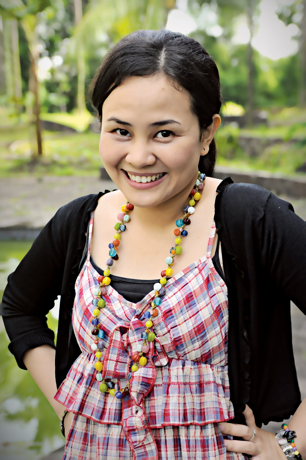 a woman with an necklace in front of a tree