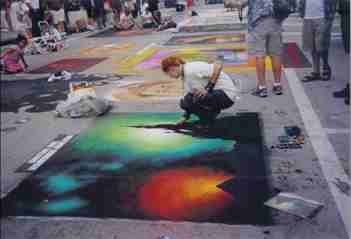 people standing on the street and drawing on a ground with chalk