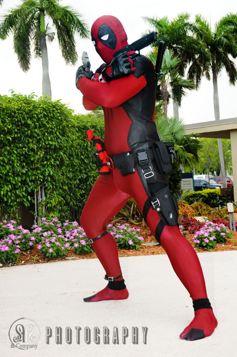 deadpool cosplay standing on one foot wearing red and black