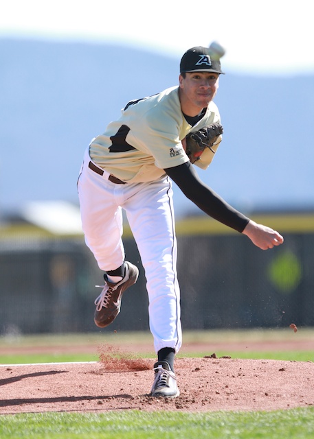 a baseball player in white and black is winding up to pitch
