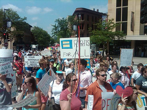 a crowd of people holding signs and banners in a street