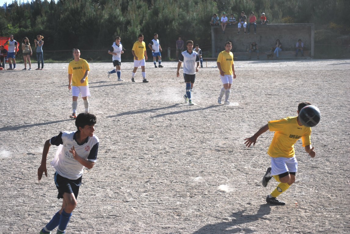 children in uniforms playing soccer on a field