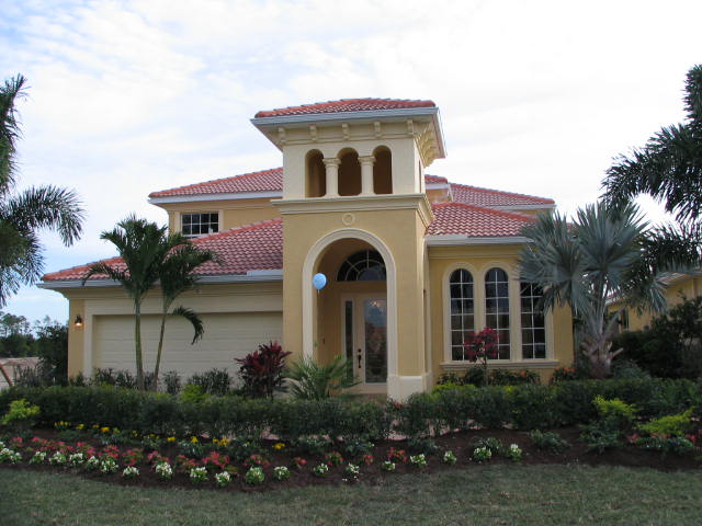 a large home that has bushes around it