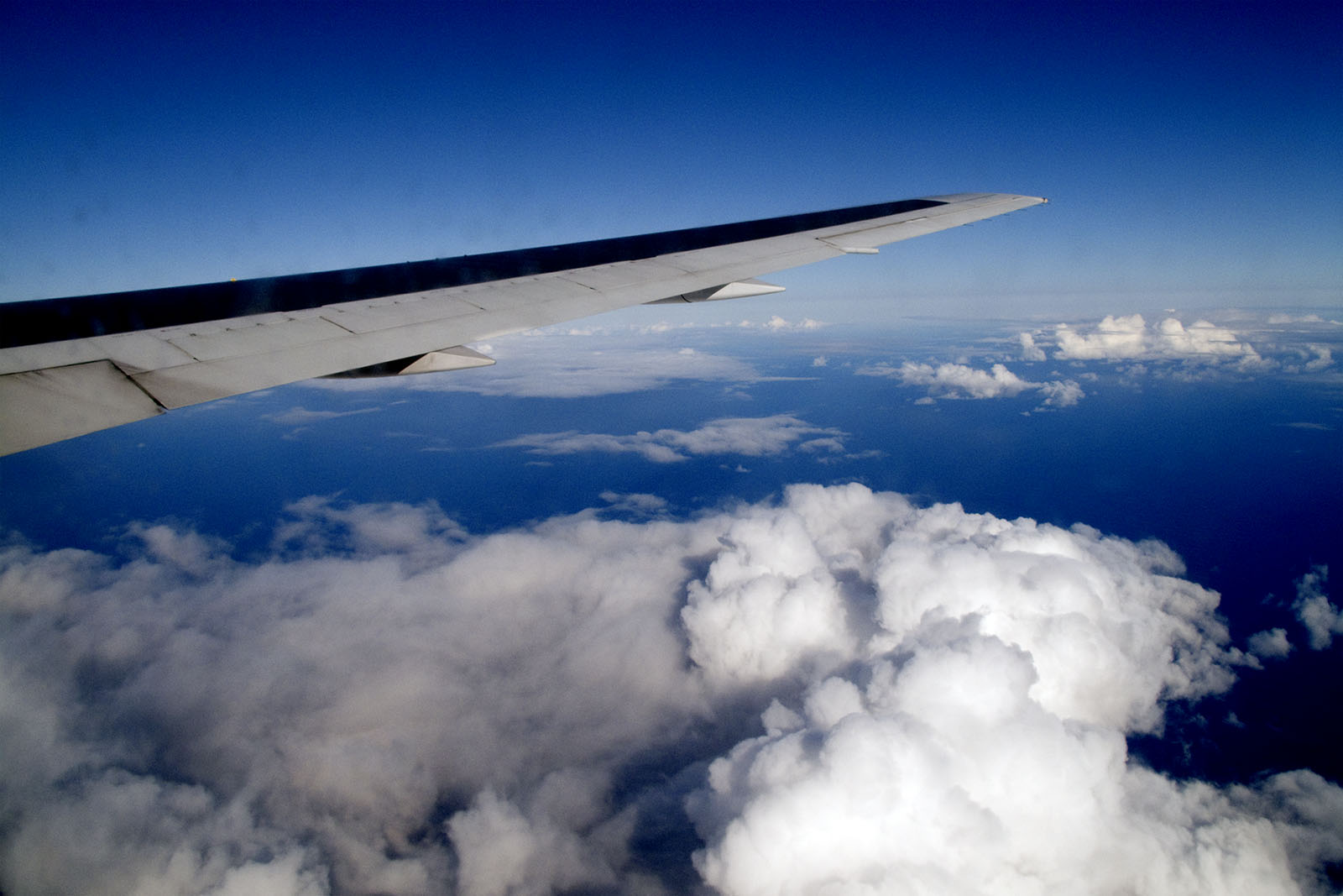 a airplane wing above the clouds is shown