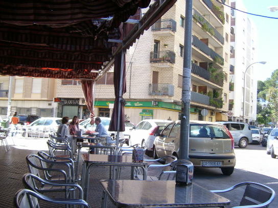 a street cafe with tables and chairs outside