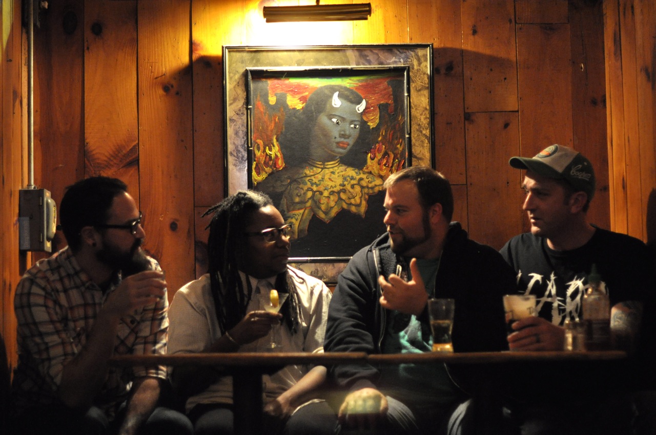 the group of three guys are sitting together talking