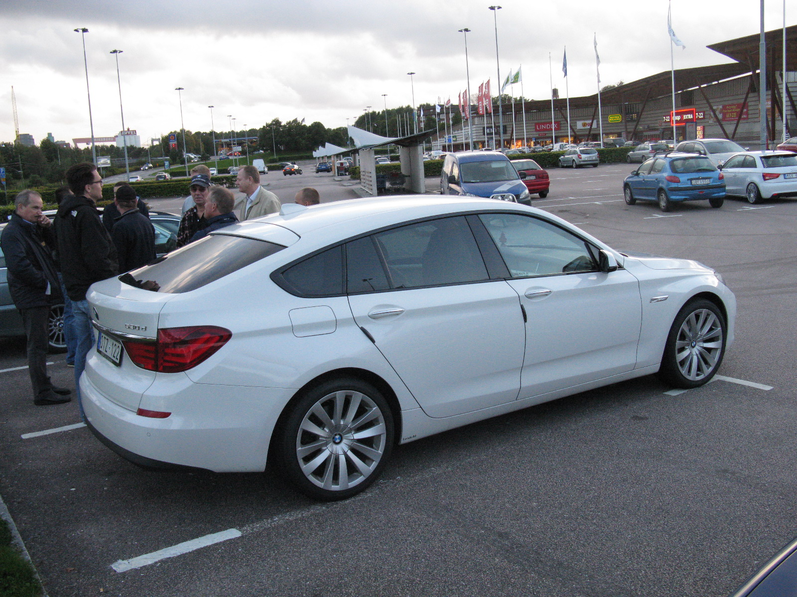 a very bright white bmw parked in a parking lot