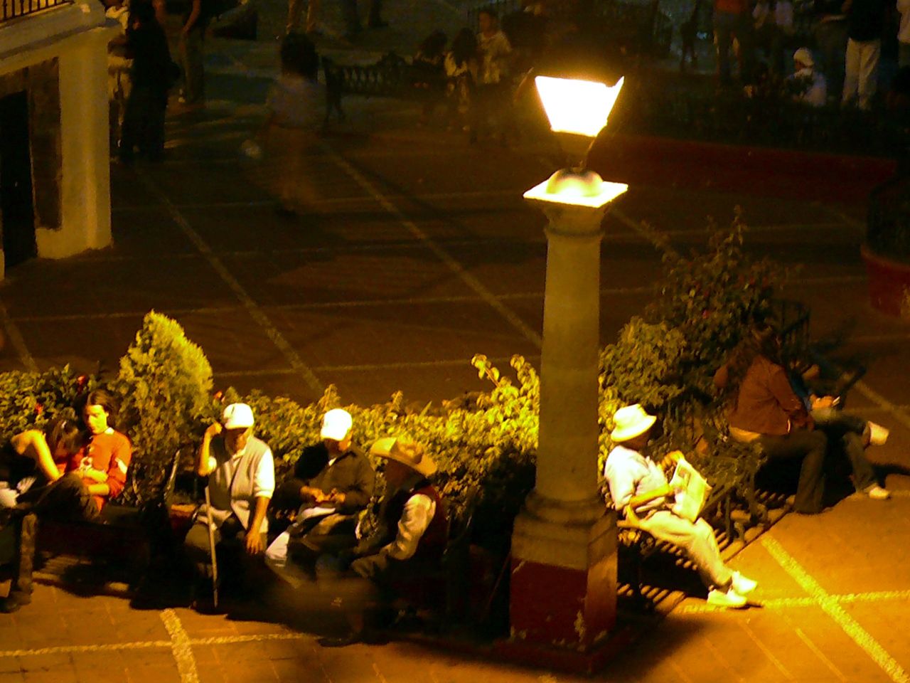 a group of people are sitting outside in the evening