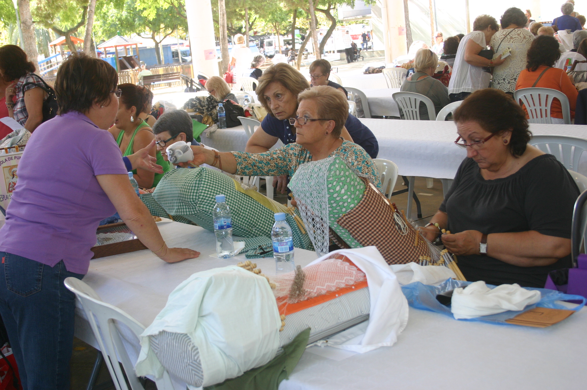 group of women sitting at tables in an outdoor market