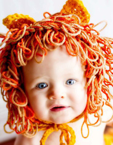 a baby with multicolored hair and a fake lion costume
