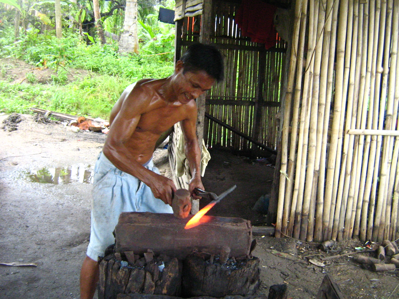a man blacksmiths on a  piece of iron