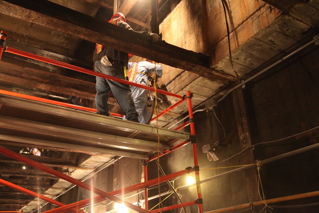 two workers in a construction zone are working on a structure