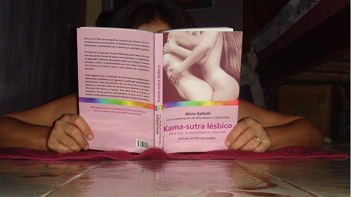a person laying down reading a pink book