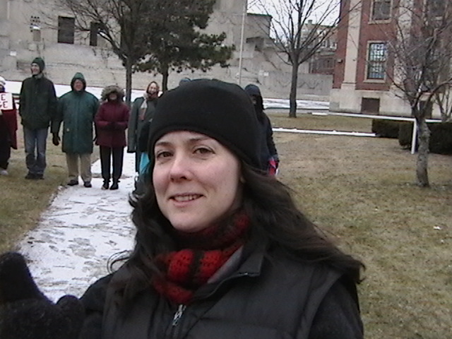 a person standing on a sidewalk with a sign in front of them