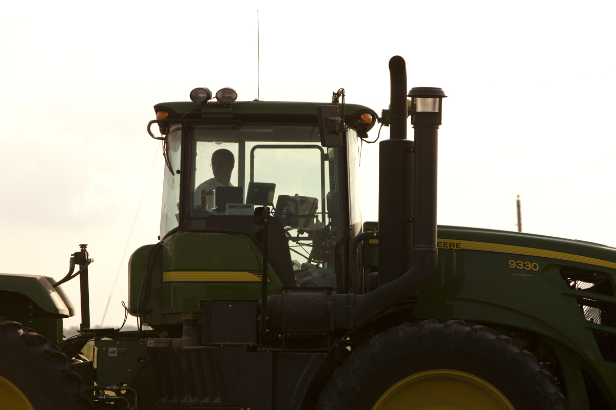 the farm tractor is driving in the open field