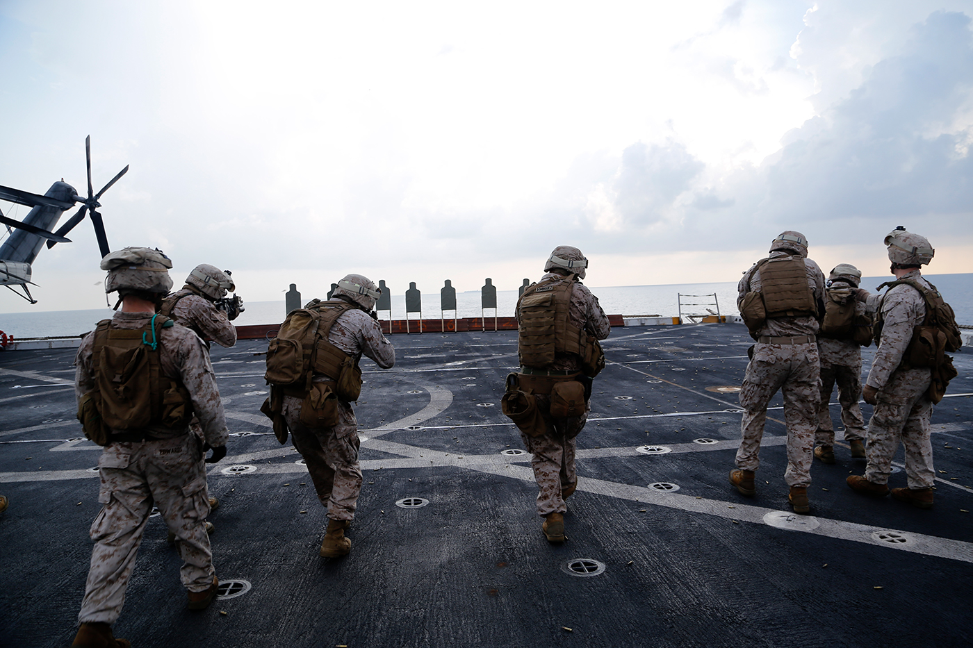 military personnel standing around an aircraft carrier