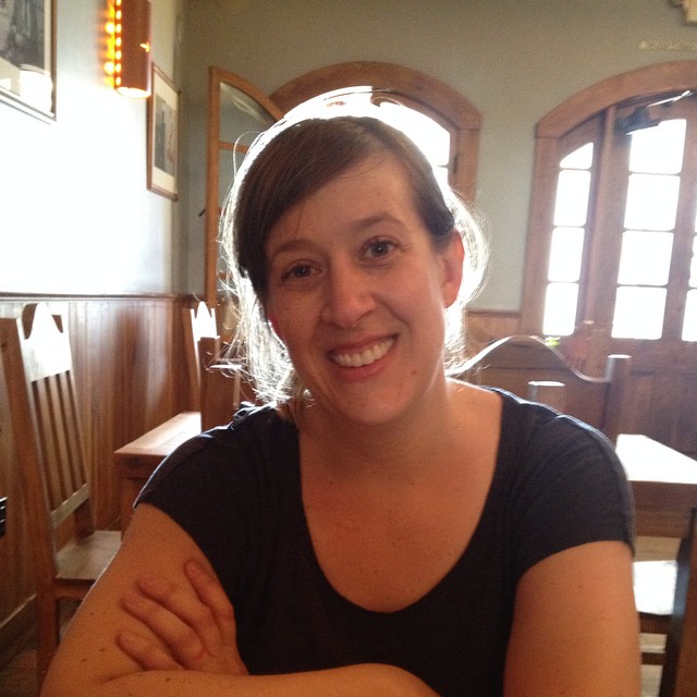 woman sitting at table in front of an apple pie