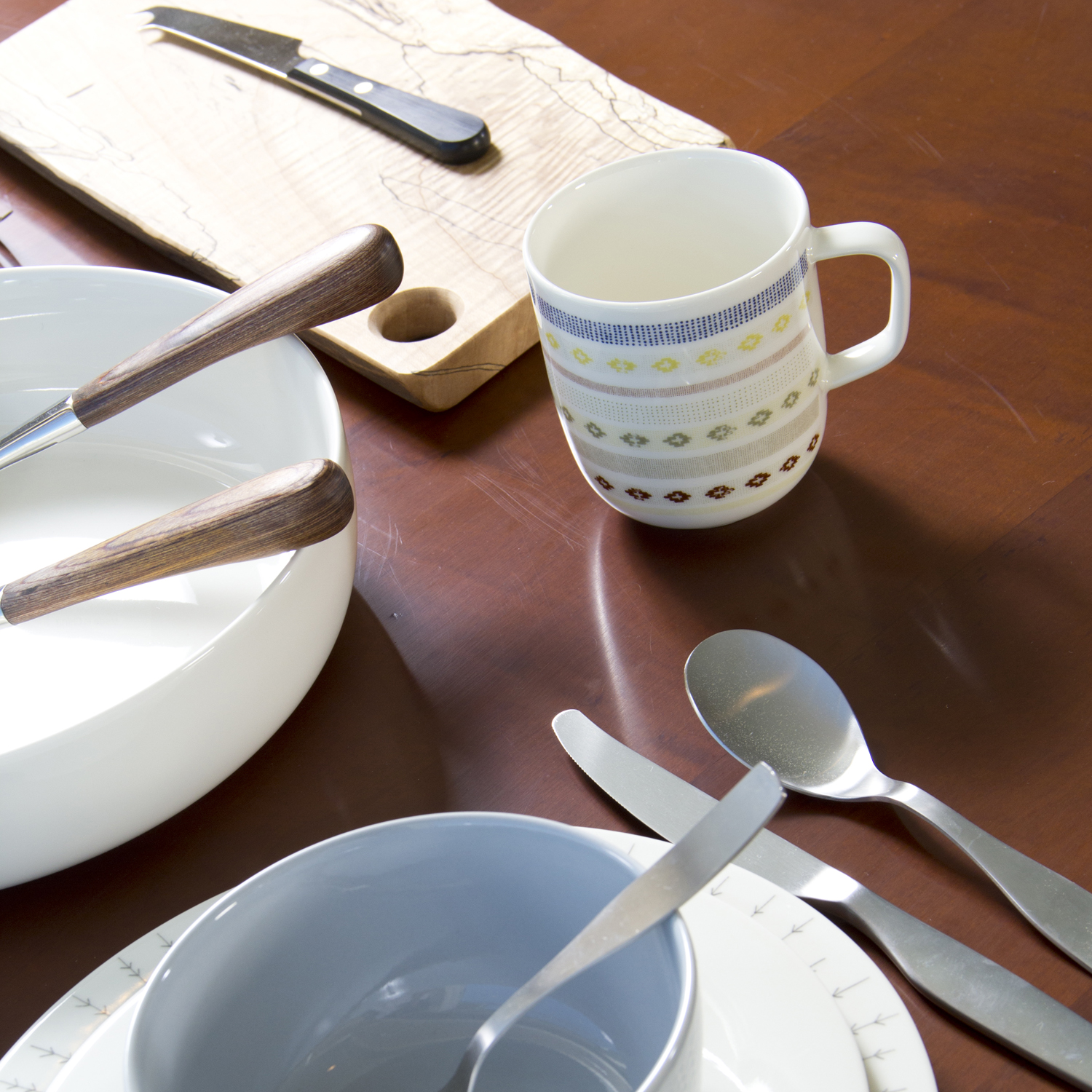 a table with a coffee cup and some empty plates