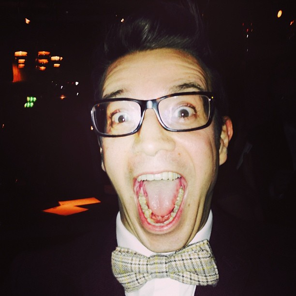a man with glasses and bow tie making a funny face