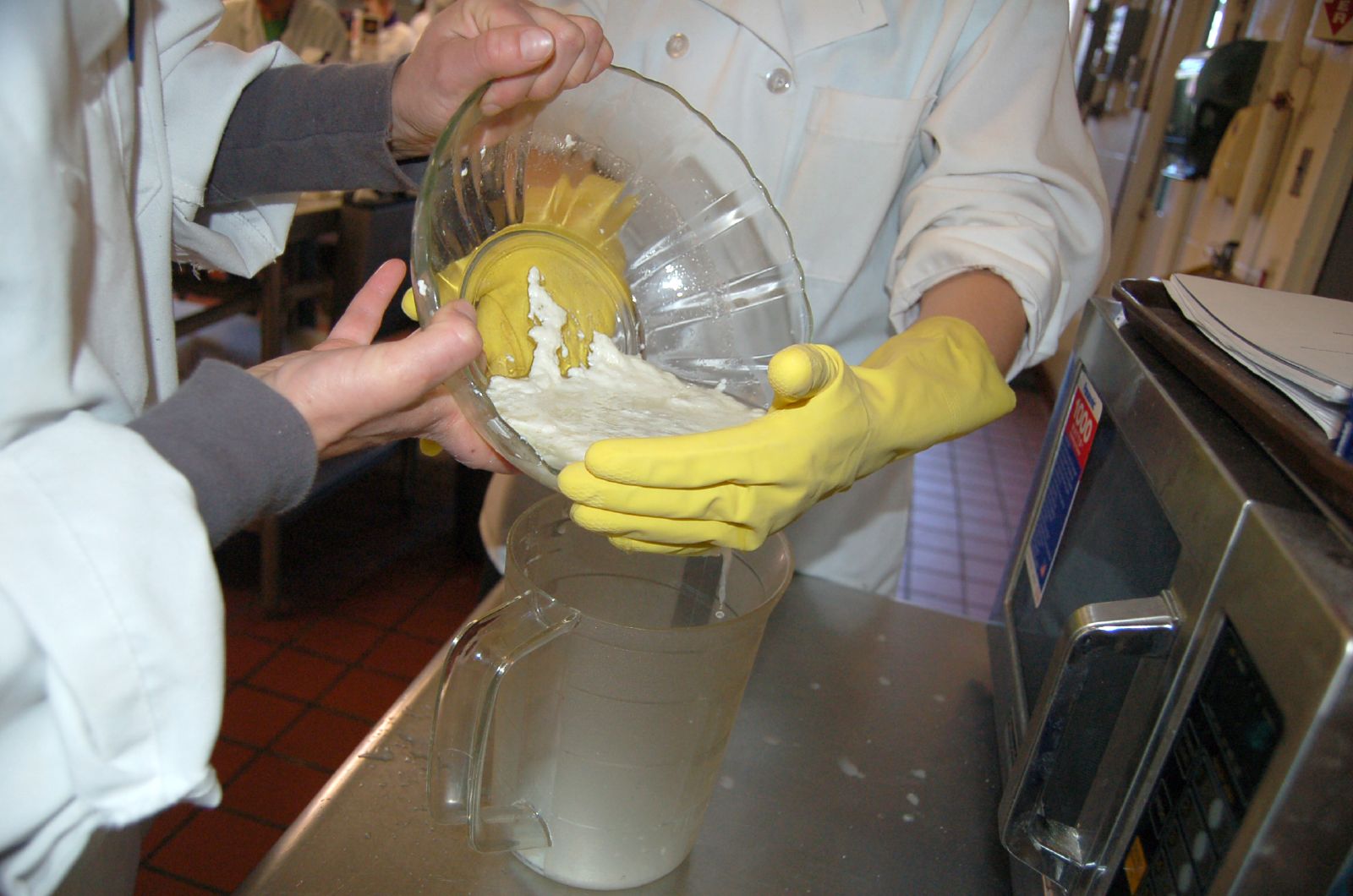 a close up of a person in gloves mixing some food