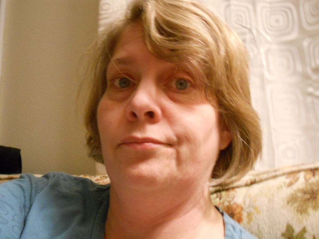 a woman is looking into the camera in a blue shirt