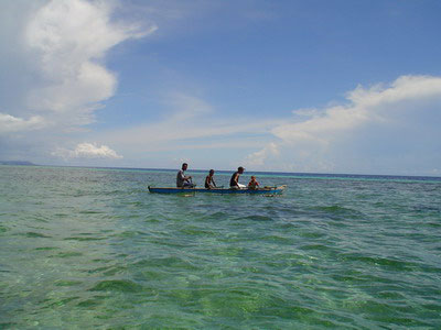 several people in a boat on a blue ocean