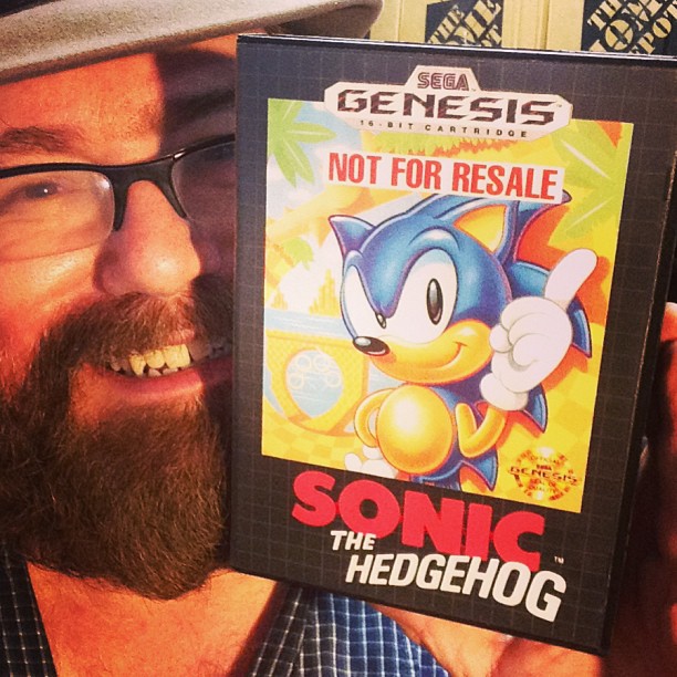 a man is showing off the official cover of sonic the hedgehog game