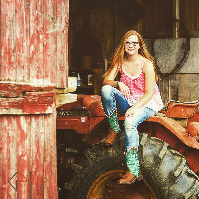 a  with long red hair sitting on a tractor