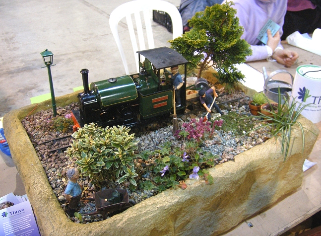 a garden with a train and figurines