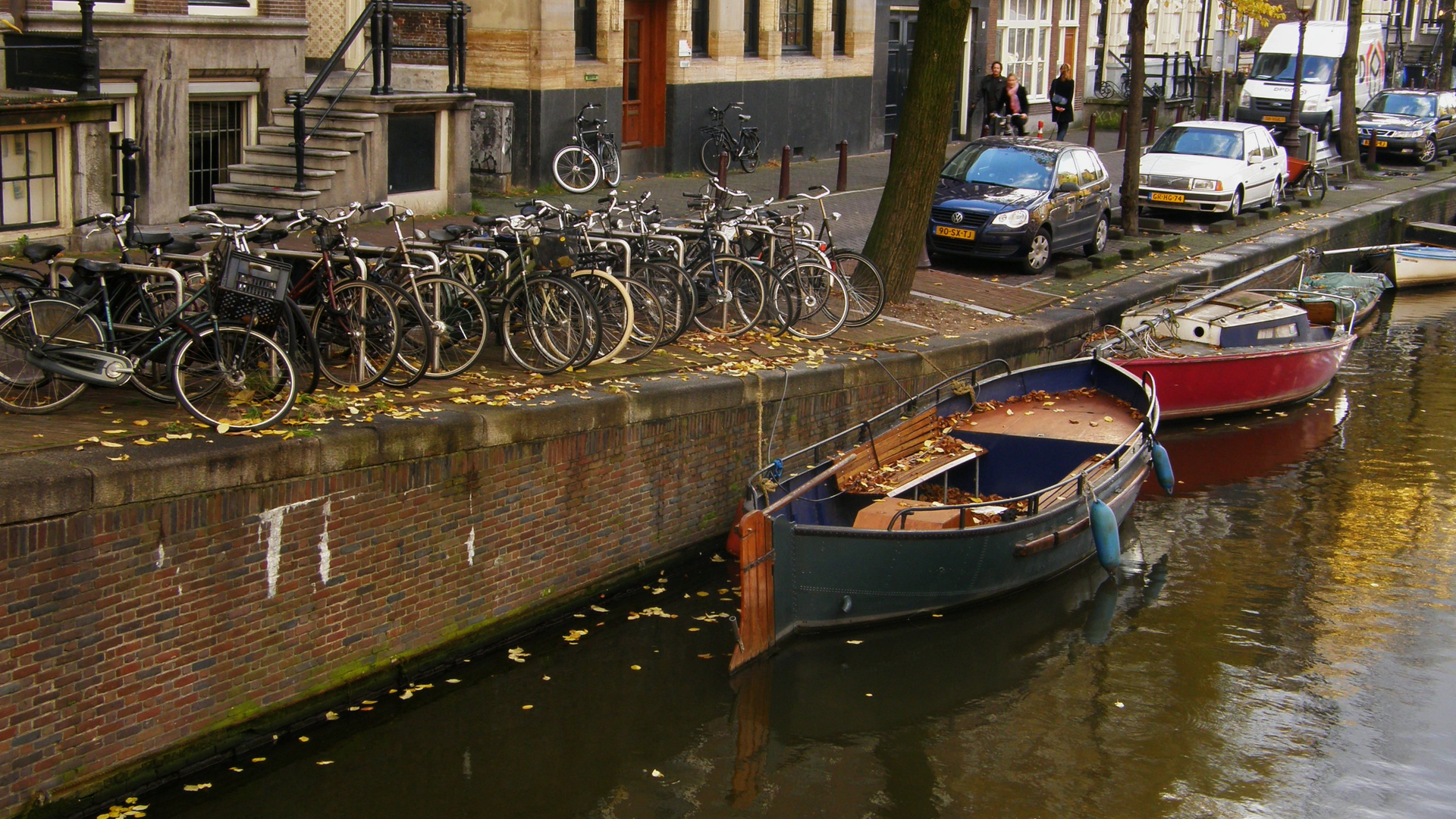 a group of bikes and motor boats parked along the side of a river