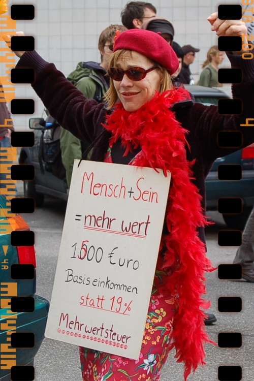 a woman with red feathers holding a sign