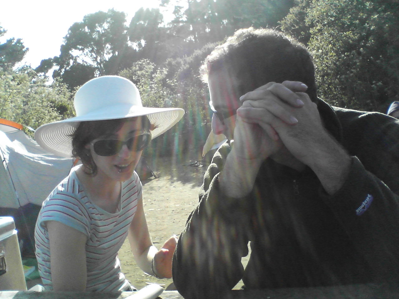 a woman is covering her eyes and a man in a hat