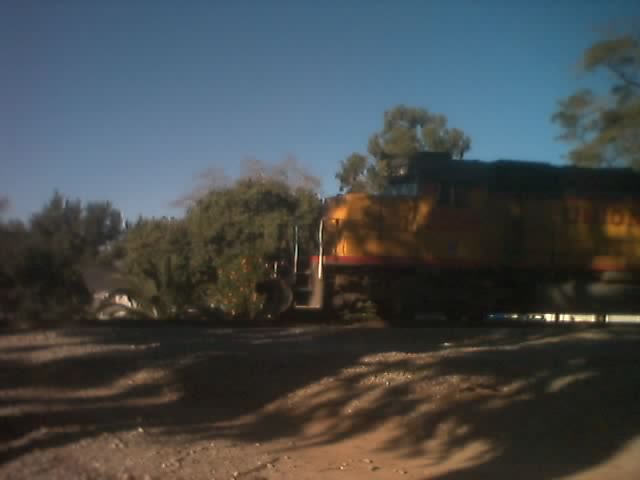 a train traveling down tracks with trees in the background