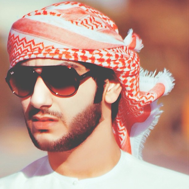 the man wearing a head scarf is wearing sunglasses and a bandanna