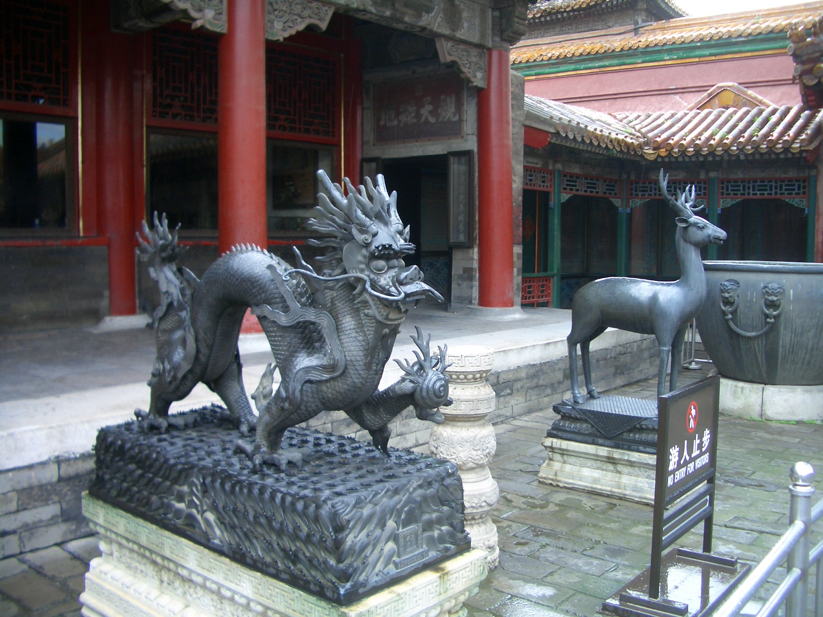 two dragon statues are shown in front of chinese building