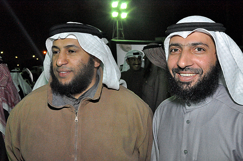 two guys dressed in traditional clothing smile for the camera