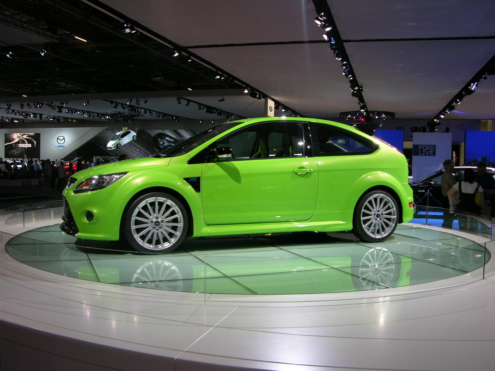 a green car sits on display at an auto show