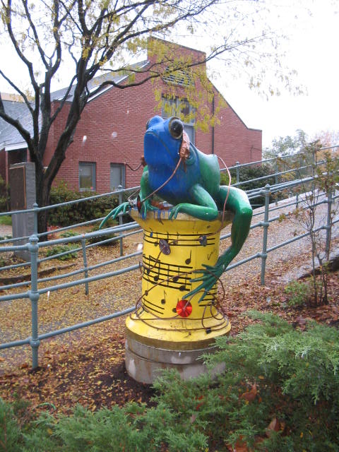 a sculpture that looks like it's holding a yellow fire hydrant