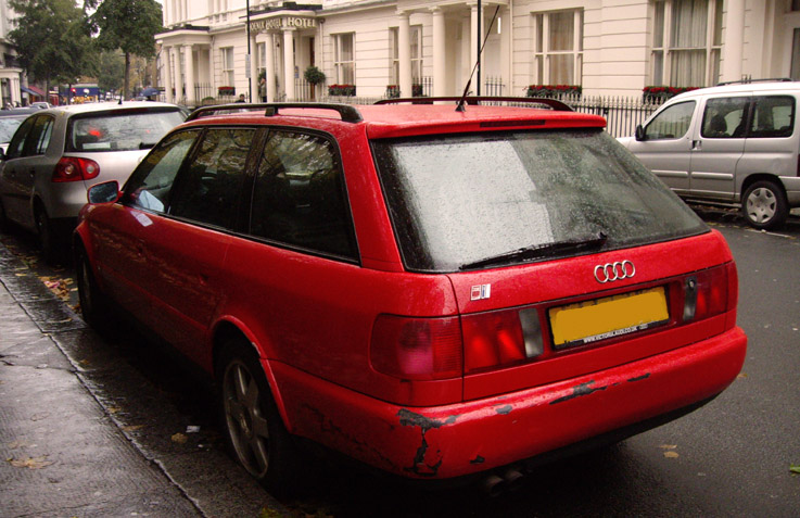 there is a red car that has been parked in front of the houses