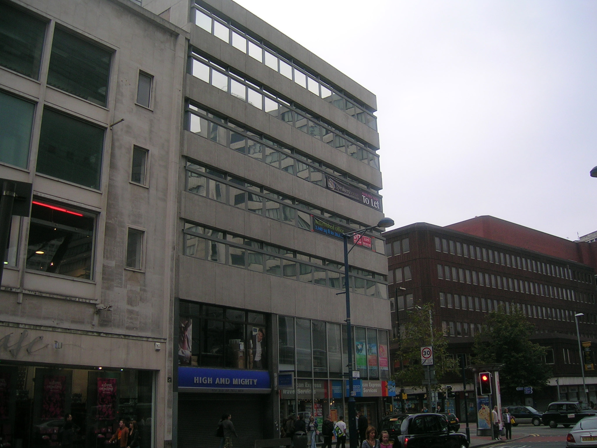 a street corner showing cars, people, and buildings