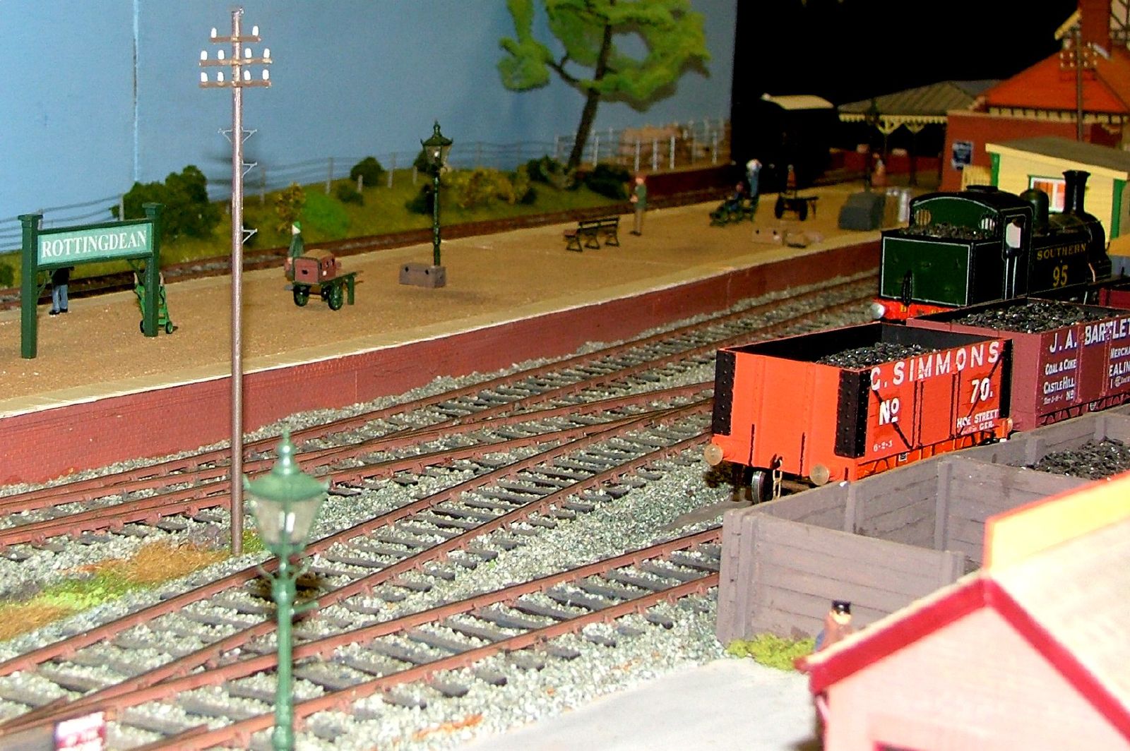 model train yard with trains and people walking near