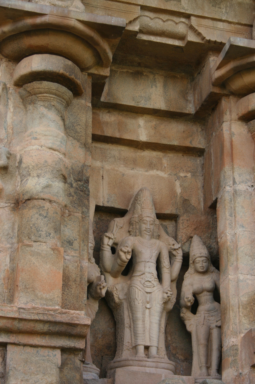 two sculptures with carved statues in front of them