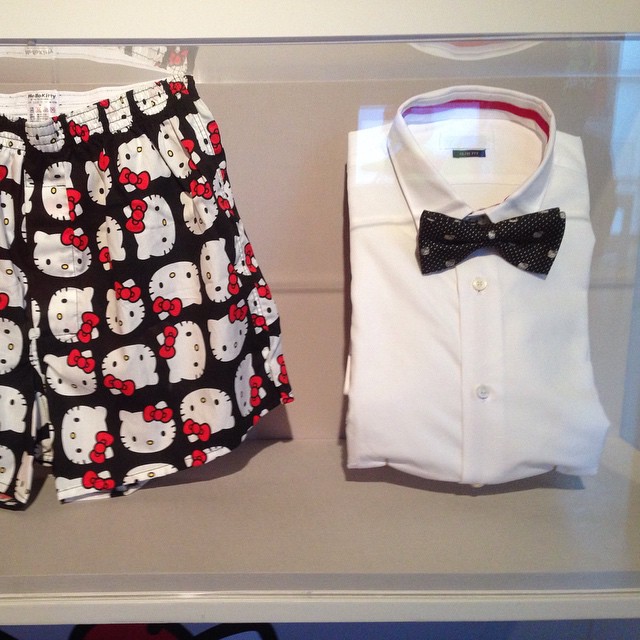 two hello kitty clothing are sitting in a display case